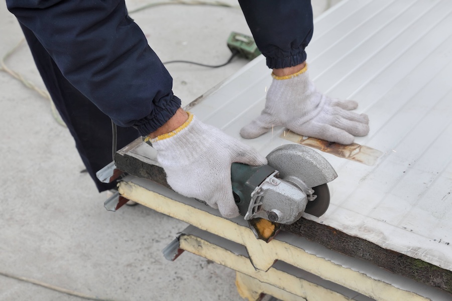 person cutting steel panel